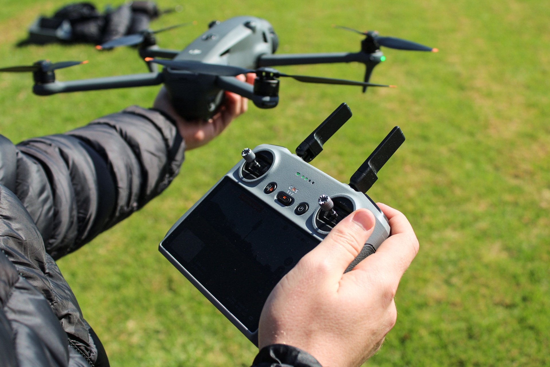 Close-up of DJI remote controller and drone during pre-flight checks